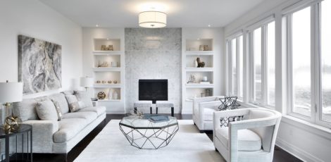 Bright great room with built-in display shelving, a gas fireplace, and oak hardwood flooring.