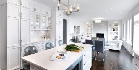 Modern, open-concept kitchen with oak hardwood flooring, granite countertops, and the breakfast area and great room beyond.