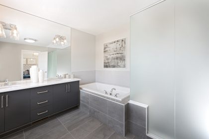 Modern 5-piece ensuite master bathroom with 2 sinks and a soaker tub with ceramic tile trimming.