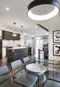 Bright open dining room with kitchen beyond.