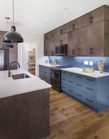 Sirius kitchen with medium wood stain upper cabinets and blue lower cabinets.